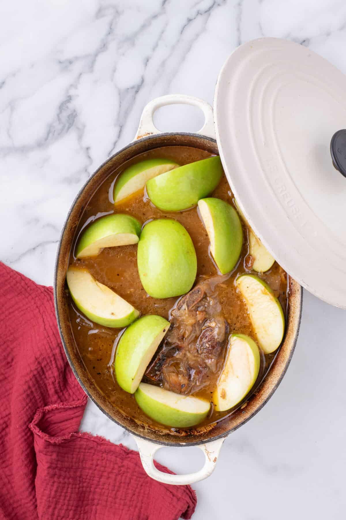 slices of Granny Smith apples over top of the pork shoulder roast in a dutch oven. 