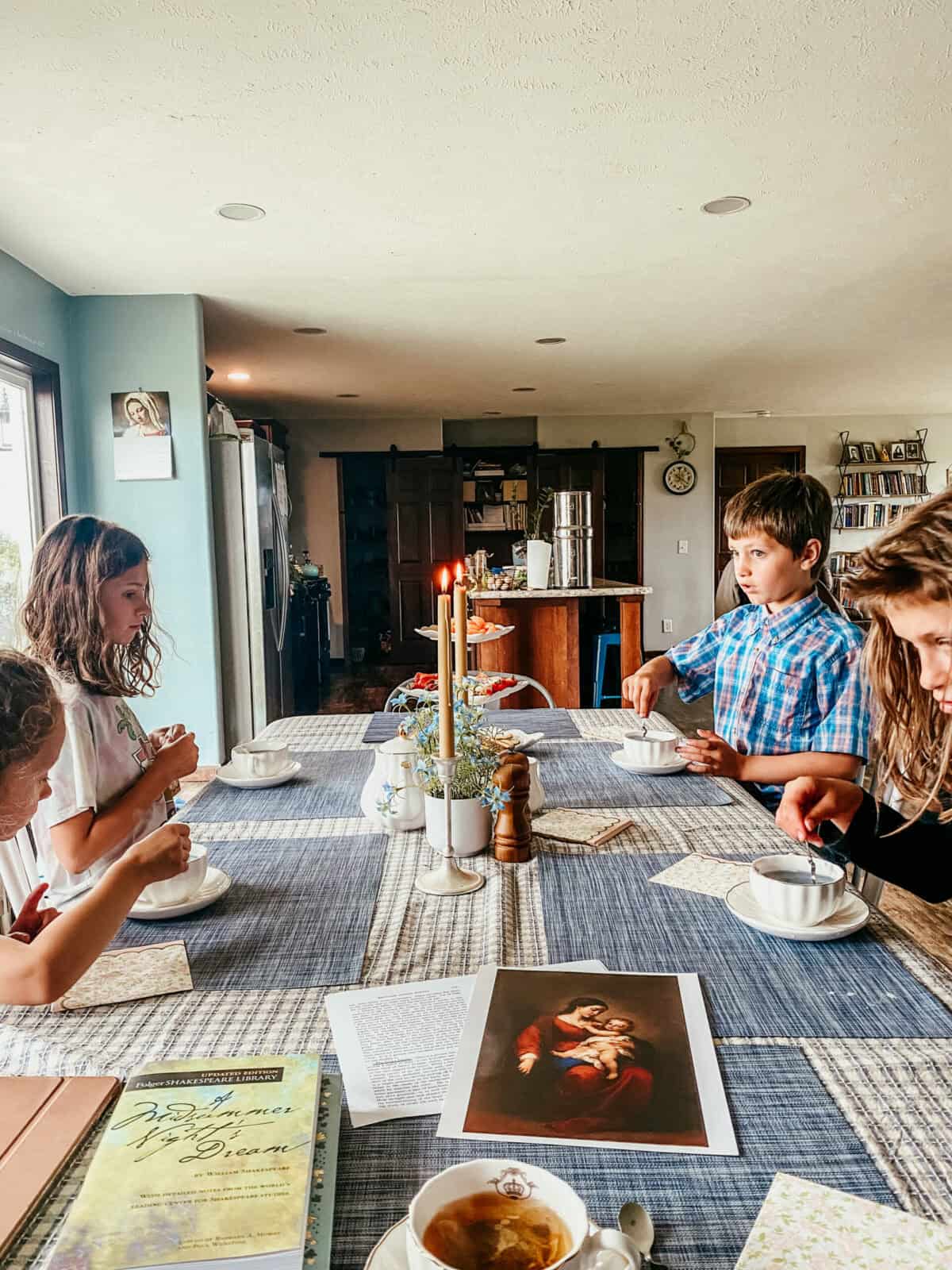 children gathered around a dining table for tea time and picture study.