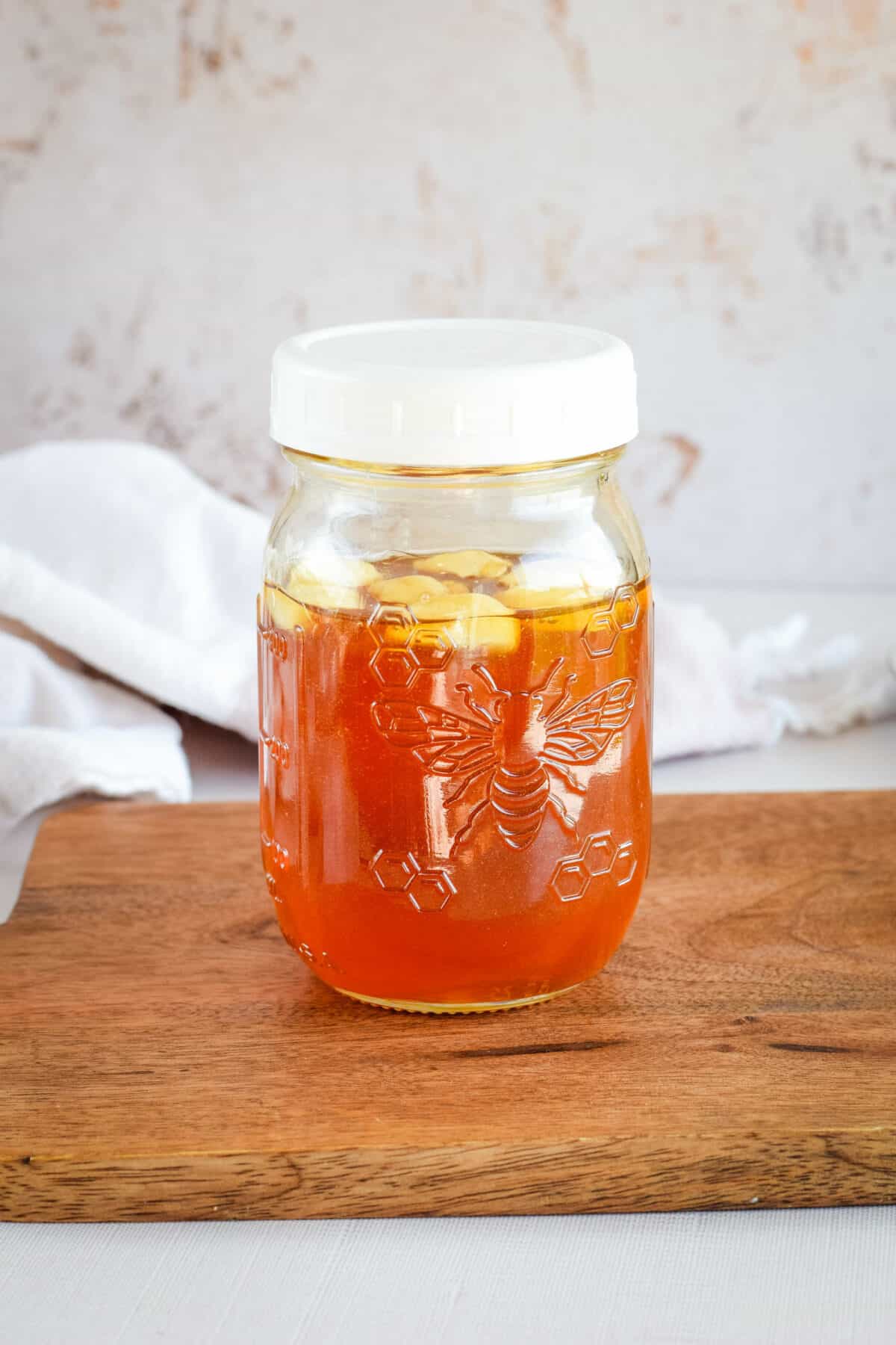 small mason jar filled with garlic infused honey.