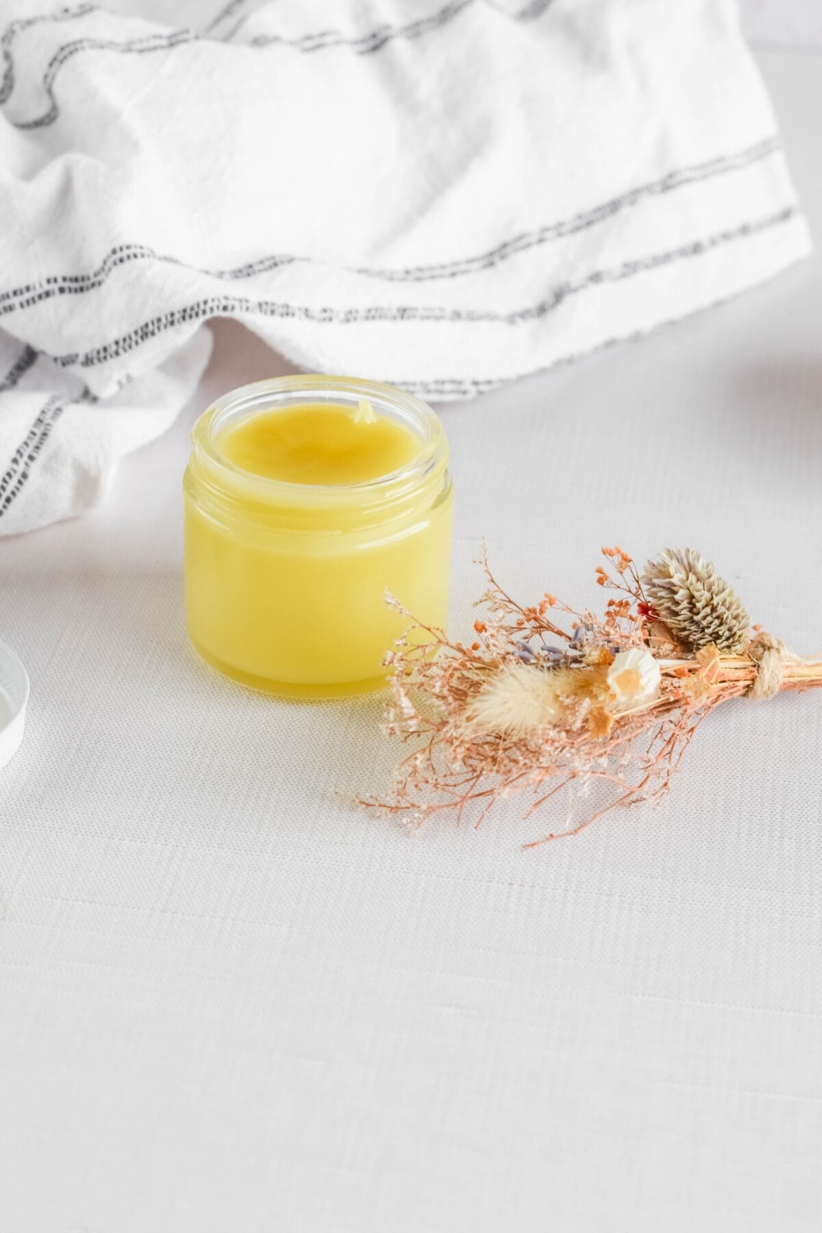 small glass jar of Homemade Eucalyptus Salve on a table.