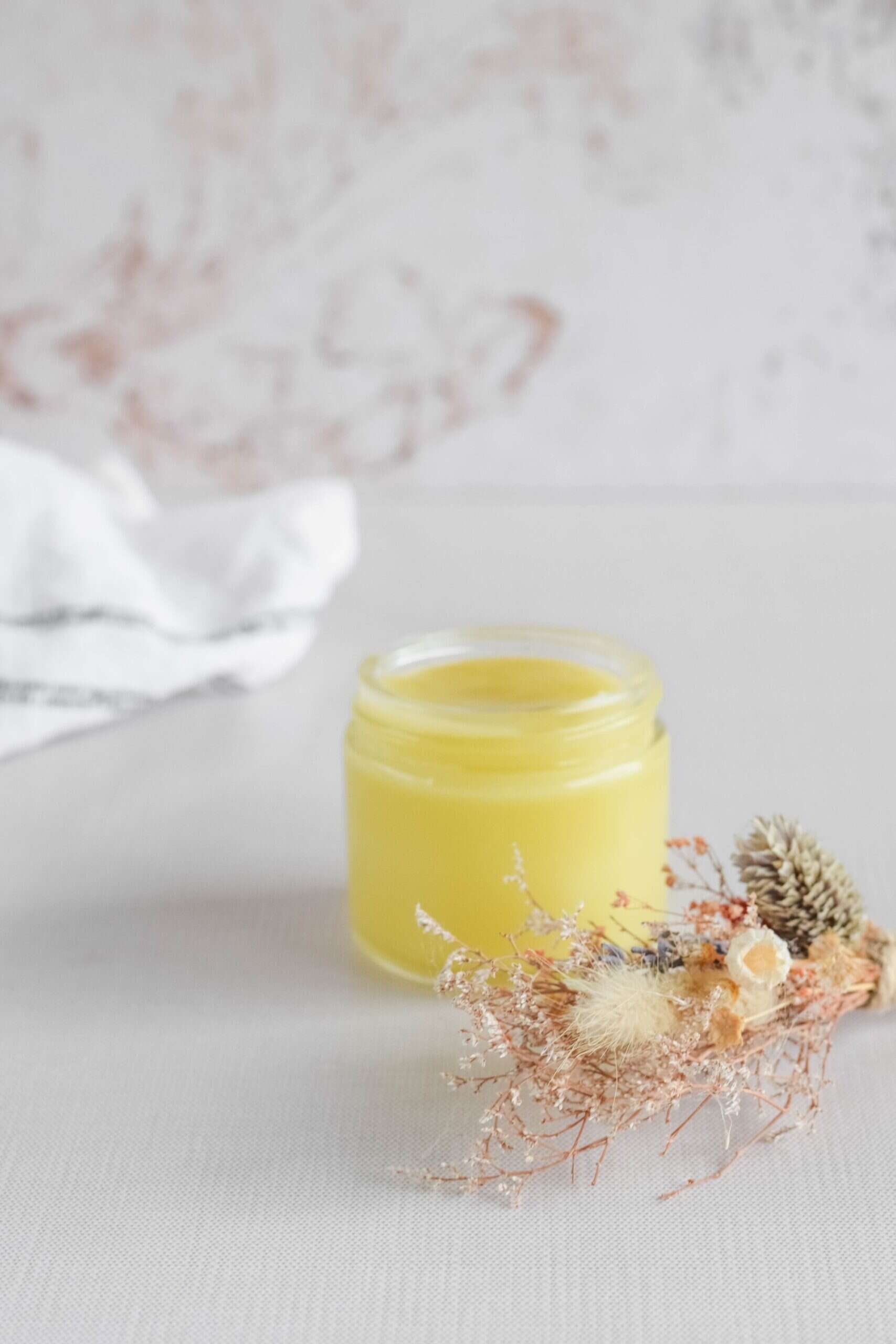 small glass jar of Homemade Eucalyptus Salve on a table.