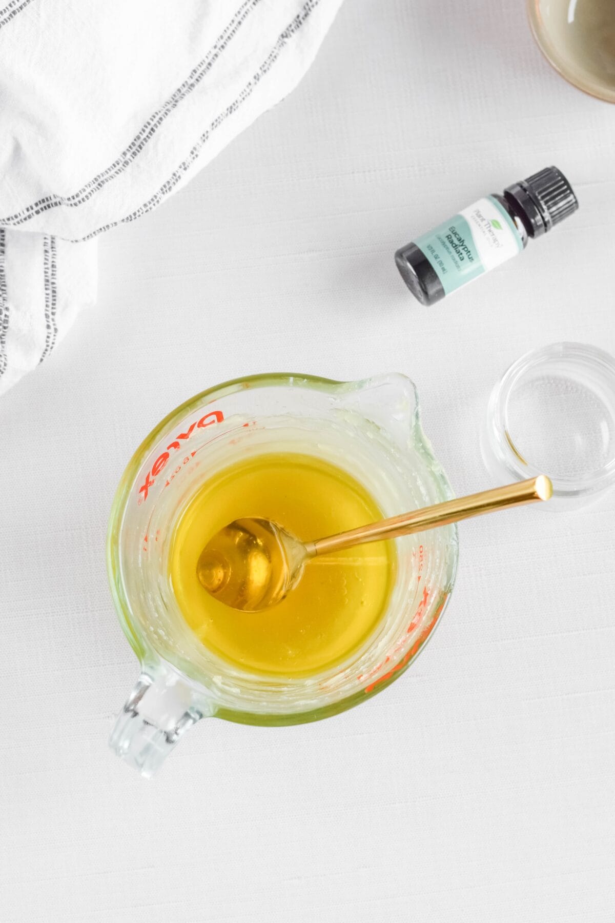 melted beeswax combined with the oils for the Homemade Eucalyptus Salve in a glass measuring cup. 