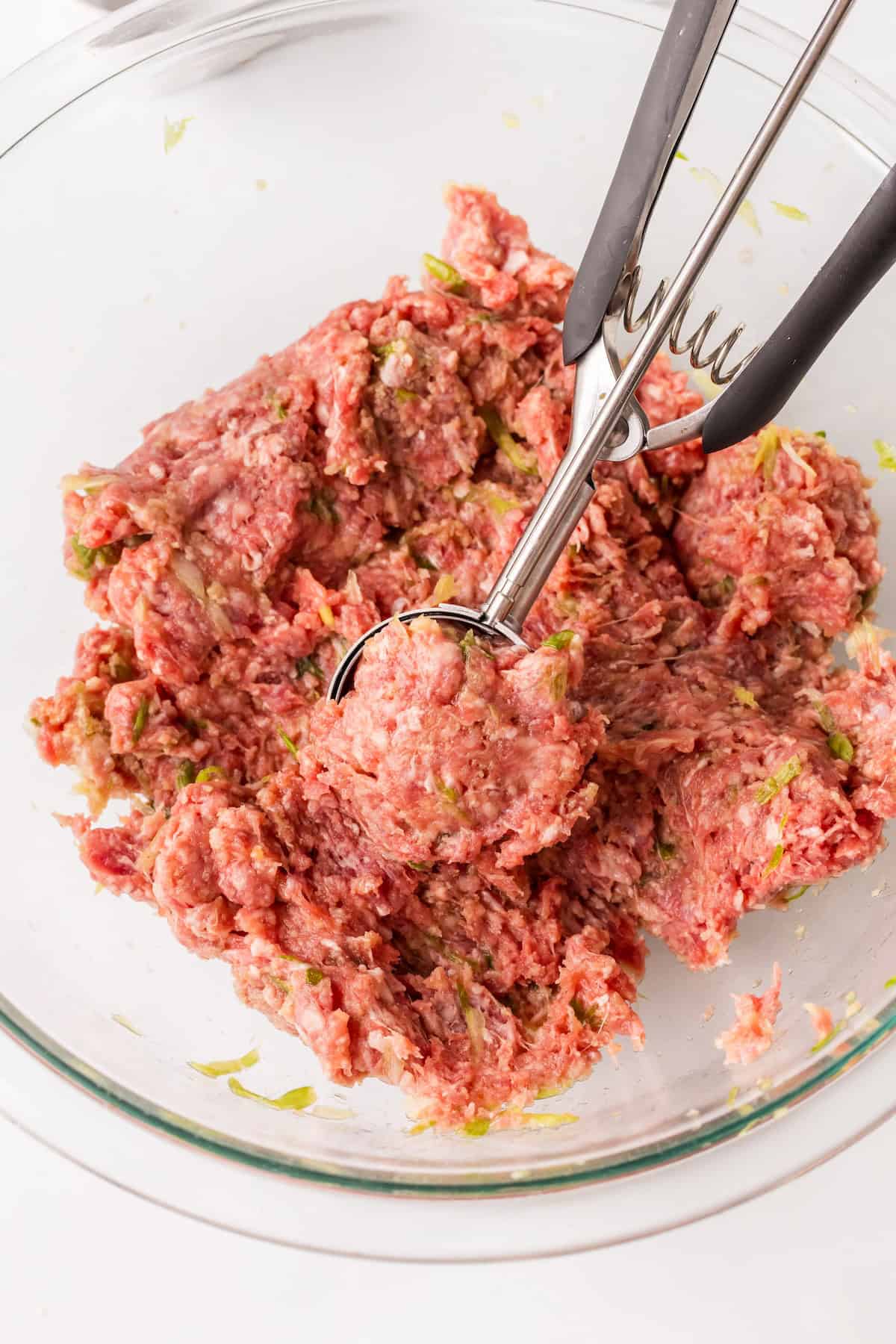 rolling the meatballs in the bowl.