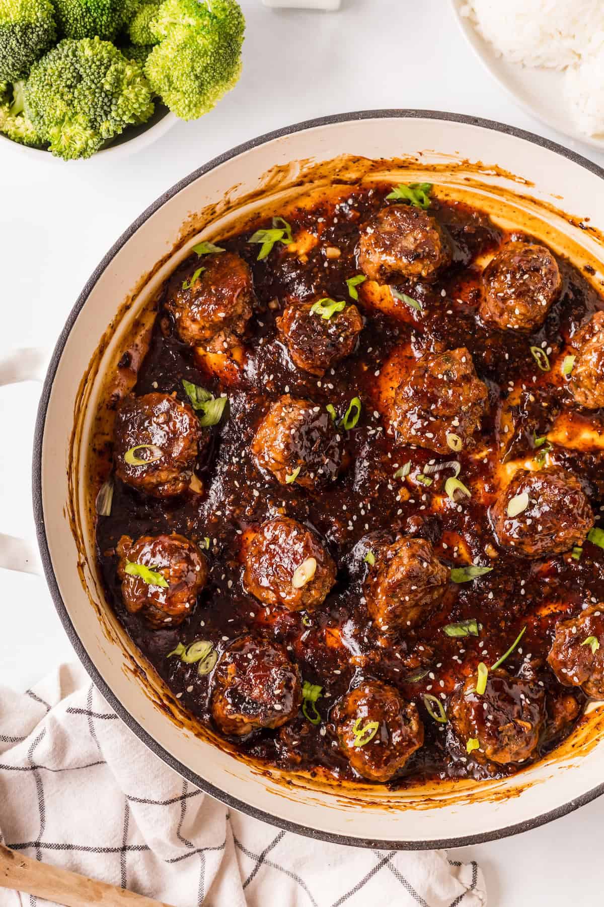 finished meatballs in a skillet with sticky sauce combined.