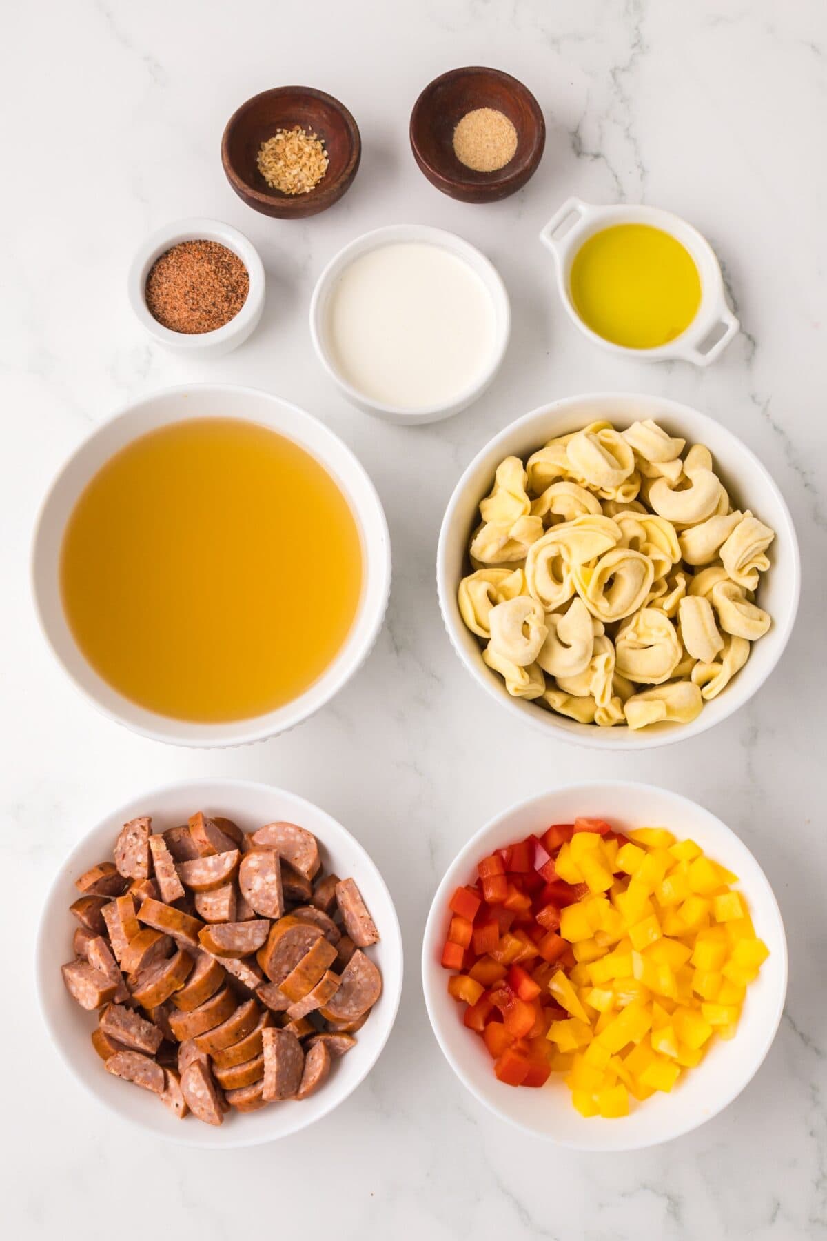 creamy cajun tortellini ingredients in small bowls on the counter top. 