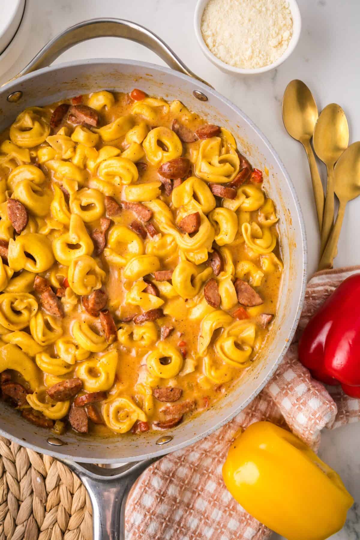 skillet with finished creamy cajun tortellini resting on a counter. 