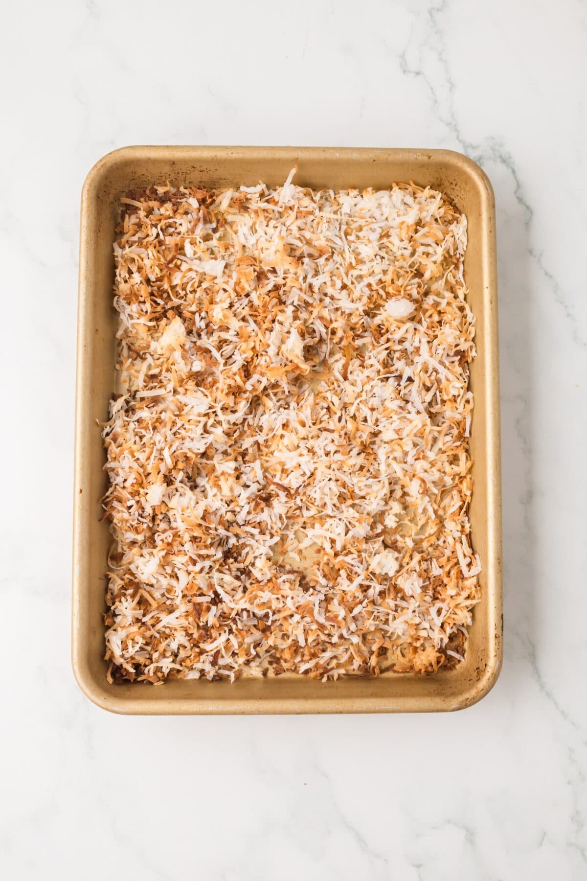 toasting the shredded coconuts on a baking sheet.